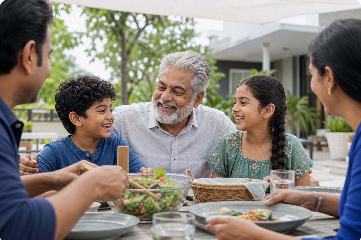 A family share a meal together in a garden